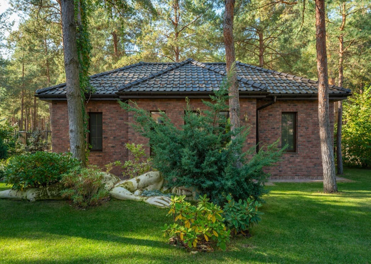 Brick home with manicured lawn and layered garden beds