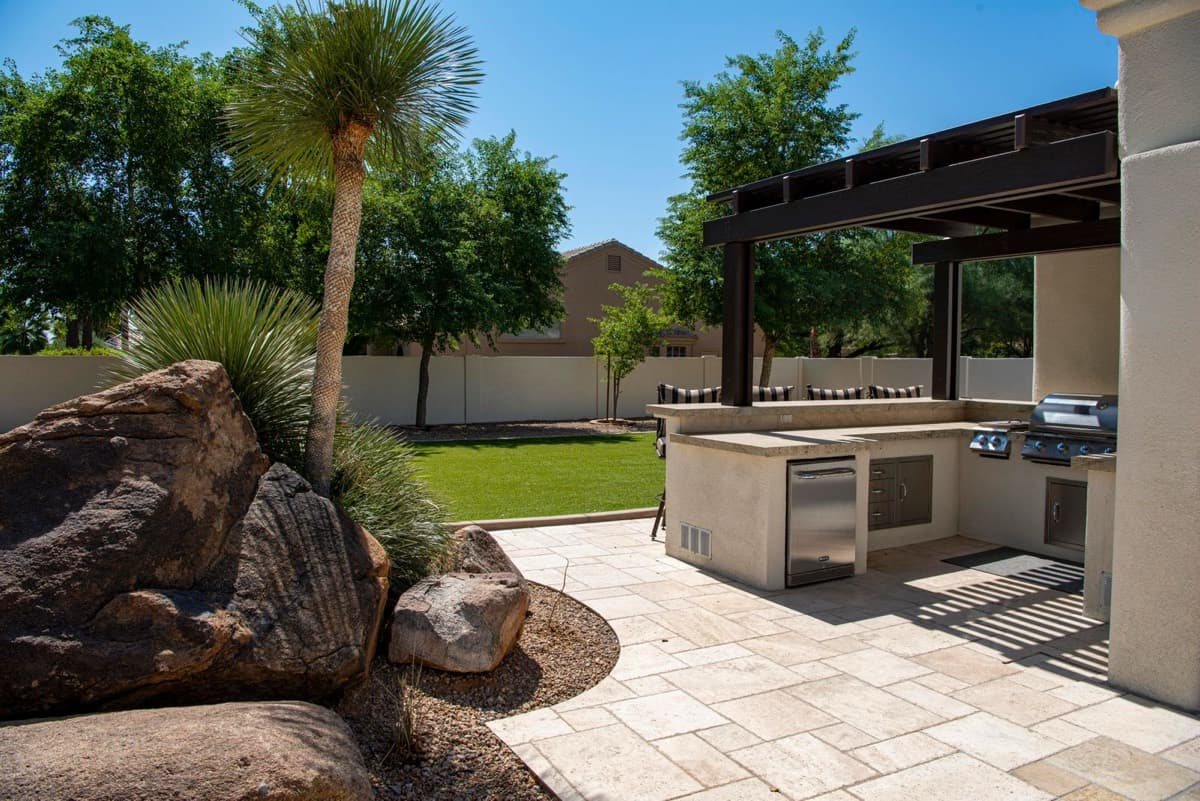 Outdoor kitchen with built-in grill under a pergola