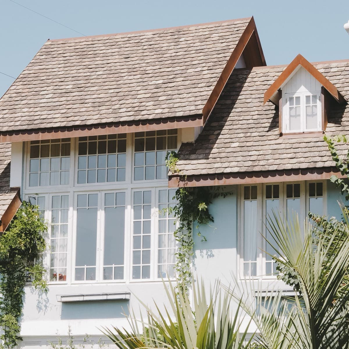 Home with cedar shake roof and dormer windows