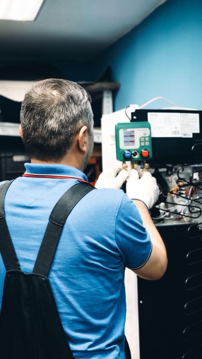 Technician commissioning a high-efficiency system with digital gauges