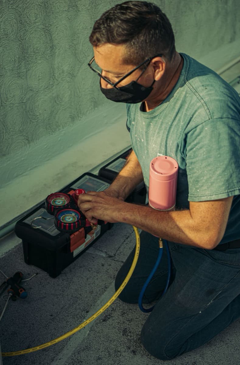Technician kneeling beside tools during a seasonal tune-up